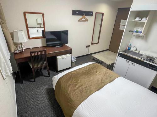 a hotel room with a bed and a desk at Takatsuki W and M Hotel in Takatsuki