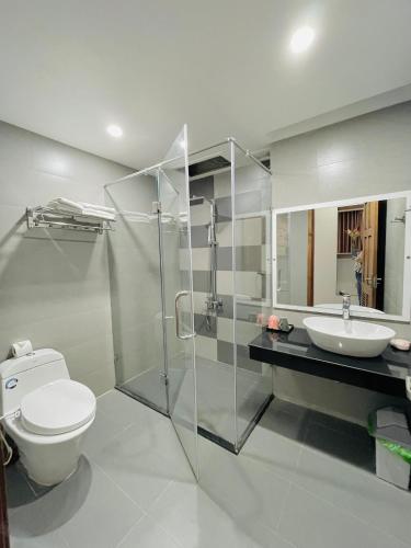 a bathroom with a toilet and a sink and a shower at SOLEIL HOSTEL in Hue