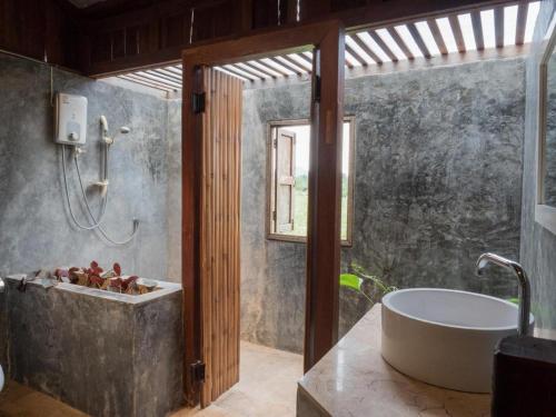 a bathroom with a bath tub and a sink at The Frog Khao Yai Resort in Ban Tha Chang