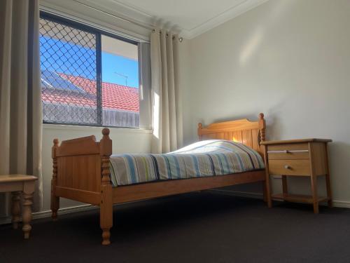 een slaapkamer met een bed en een raam bij Private Room with shared bathroom in Browns Plains