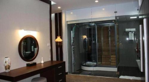 Draco - Thang Long Hotel في هاي فونج: حمام مع دش ومغسلة ومرآة