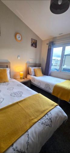 two beds in a room with a window at Bay View Lodge in Heysham