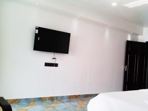 einen Flachbild-TV an der Wand in einem Schlafzimmer in der Unterkunft Romance Resort Varkala in Varkala