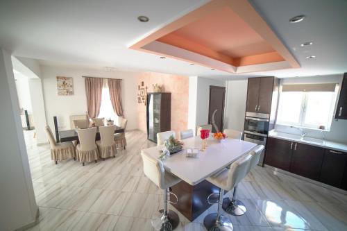 Una cocina y una sala de estar con mesa y sillas. en Villa Thea, en Moírai