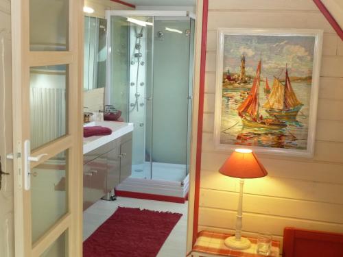 a bathroom with a shower and a lamp and a painting at Les Bruyères du Mont in Céaux
