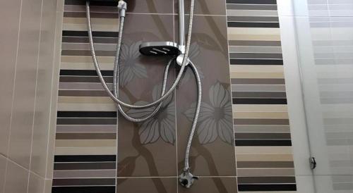 a shower with a stethoscope hanging on a wall at Med Room Korat in Ban Pra Dok