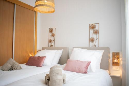 a bedroom with two beds with white and pink pillows at 2BR Ontspannen vakantiewoning in Casares