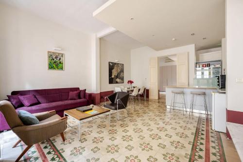 a living room with a purple couch and a table at Heart of Valletta 2BR Apartment with Patio in Valletta
