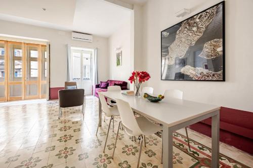 a dining room with a white table and chairs at Heart of Valletta 2BR Apartment with Patio in Valletta