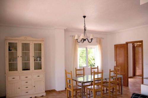 a dining room with a table and chairs and a chandelier at Apartamentos Oasis de las Palmeras in Bolnuevo