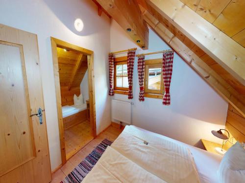 Un dormitorio con una cama en una habitación con techos de madera. en Chalet in Neukirchen, en Neukirchen am Großvenediger
