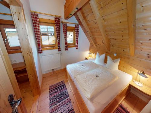 Un dormitorio con una cama en una cabaña de madera. en Chalet in Neukirchen, en Neukirchen am Großvenediger