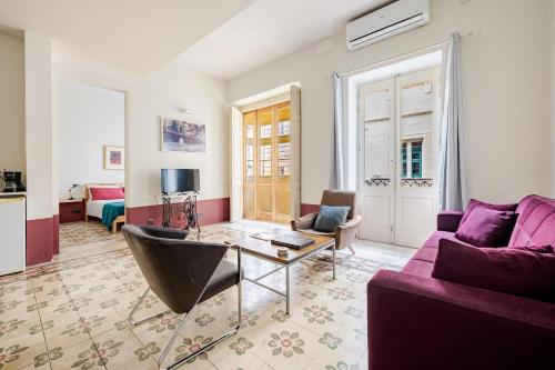 a living room with a purple couch and a table at Heart of Valletta 2BR Apartment with Patio in Valletta