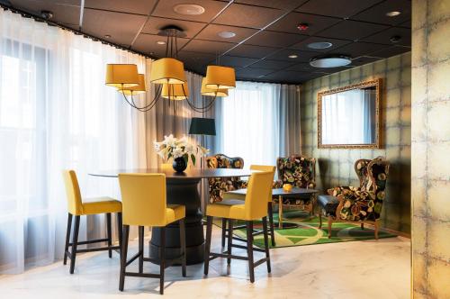 a dining room with a table and yellow chairs at Thon Hotel Stavanger in Stavanger