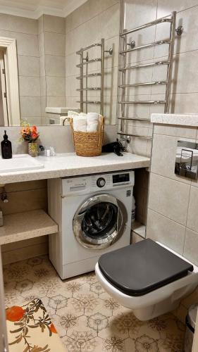 een badkamer met een wasmachine en een wastafel bij Apart on Arbat Standard in Simkent