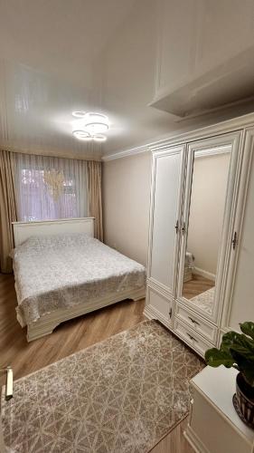 een slaapkamer met een bed en een grote kast bij Apart on Arbat Standard in Simkent