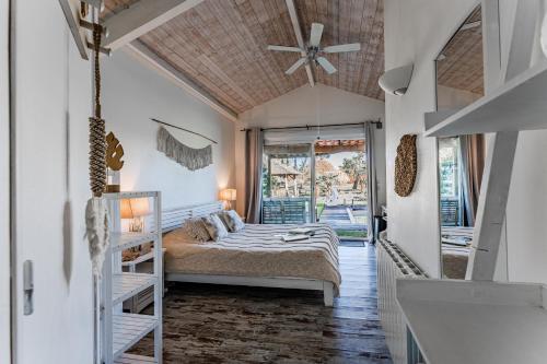 a bedroom with a bed and a ceiling fan at Villa Saint Barth in Gujan-Mestras