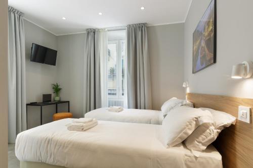 a hotel room with two beds and a tv at Hotel 22 Marzo in Milan