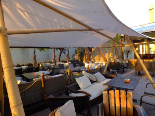 a patio with chairs and tables and a white umbrella at Pirates Resort in Mamaia