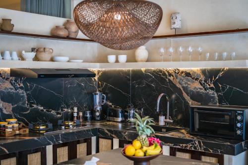 a kitchen with a black marble counter top and a sink at Casa Beso Balangan in Badung