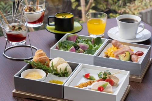 高山市にあるhotel around TAKAYAMA, an Ascend Collection Hotelのテーブルの上に飲み物が入った食べ物のトレイが2つ