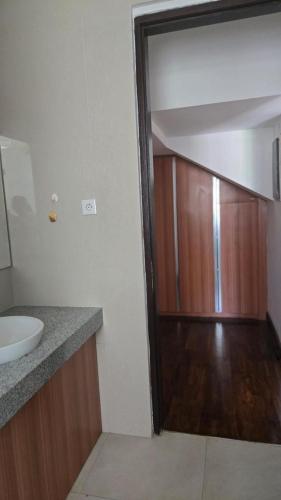 een badkamer met een wastafel en een houten deur bij Villa Don Bose 8 in Jimbaran