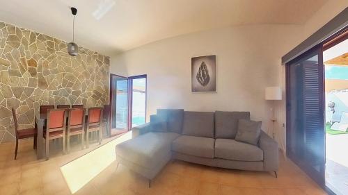 ein Wohnzimmer mit Sofa und Tisch in der Unterkunft La Maison de Montse - Piscine Privée in Corralejo