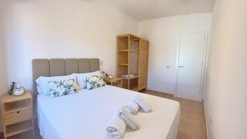 ein Schlafzimmer mit einem großen weißen Bett mit Handtüchern darauf in der Unterkunft La Maison de Montse - Piscine Privée in Corralejo