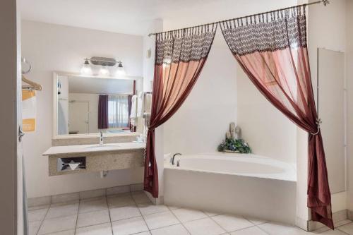 a bathroom with a tub and a sink at Quality Inn & Suites Lake Havasu City in Lake Havasu City