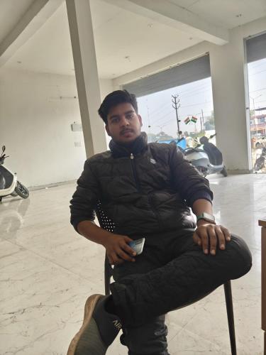 AyodhyaにあるRishabh guest houseの椅子に座る男
