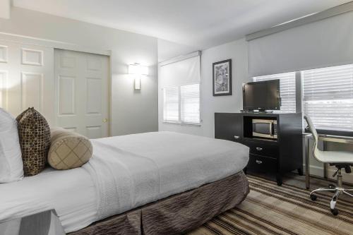 a bedroom with a bed and a desk and a television at Inn Off Capitol Park, an Ascend Collection Hotel in Sacramento