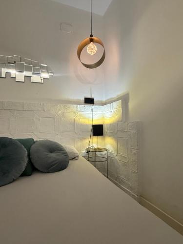 a bedroom with a large white bed and a lamp at Gollum-Goretti House in Mairena del Aljarafe