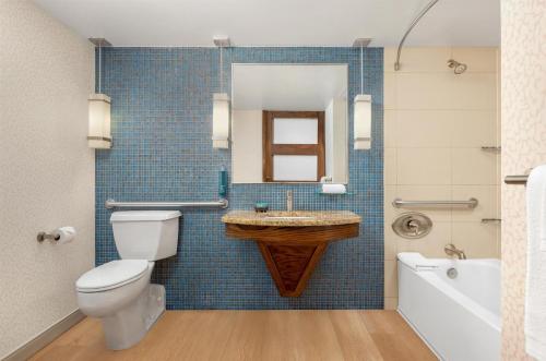 ein Badezimmer mit Toilette, Waschbecken und Badewanne in der Unterkunft Hilton Palacio del Rio in San Antonio