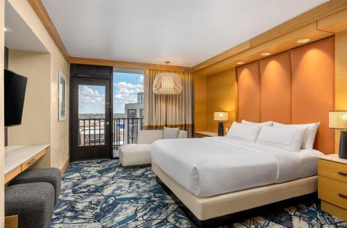 a hotel room with a bed and a balcony at Hilton Palacio del Rio in San Antonio