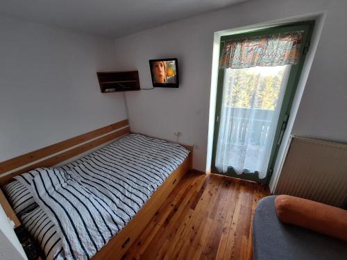 Un dormitorio pequeño con una cama y una ventana. en Apartma Ajdovka Rogla, en Rakovec