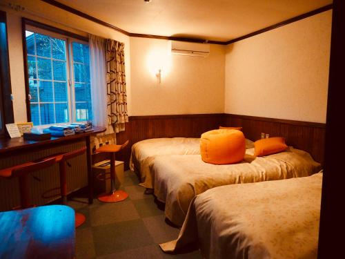 八幡平市にある安比 アース カラーのホテルルーム ベッド2台(オレンジの枕付)