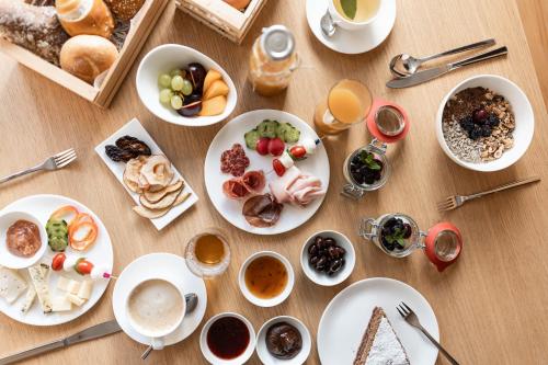 un tavolo in legno ricoperto di piatti di cibo e bevande di Füchslhof a Marlengo