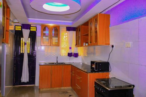 cozy coop : مطبخ بخزائن خشبية وسقف أرجواني