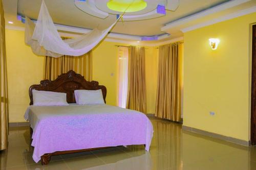 cozy coop : غرفة نوم بسرير كبير عليها شراشف وردية وسقف