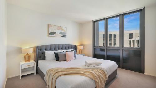 een slaapkamer met een groot bed en een groot raam bij Marina Belle in Shellharbour