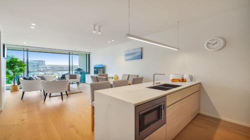 a kitchen and dining room with a clock on the wall at Marina Belle in Shellharbour