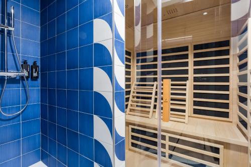 a blue tiled bathroom with a shower and a chair at CX Naples Centrale in Naples