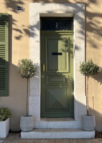 a green door on a building with two potted plants at Sea Front in La Ciotat