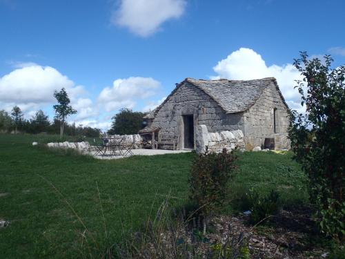 une ancienne grange en pierre dans un champ d'herbe dans l'établissement Chapelle du Domaine de Bombes, à Saint-Rome-de-Dolan