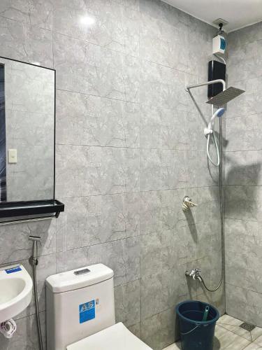 a bathroom with a shower and a toilet and a sink at Los Glomos RestHub in Los Baños
