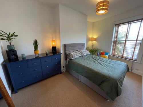 um quarto com uma cama e uma cômoda, sendo a cômoda azul. em Cosy Cottage Apperley Bridge em Apperley Bridge