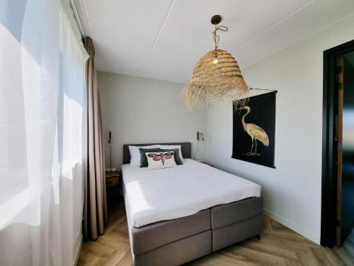 Luxurious detached water villa with jetty في Balk: غرفة نوم بسرير ومصباح معلق