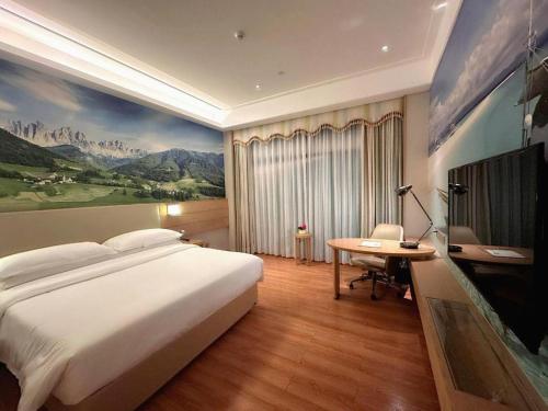 Un dormitorio con una gran cama blanca y un escritorio. en Vienna Best Sleep International Hotel Shenzhen New Airport Branch, en Baoan