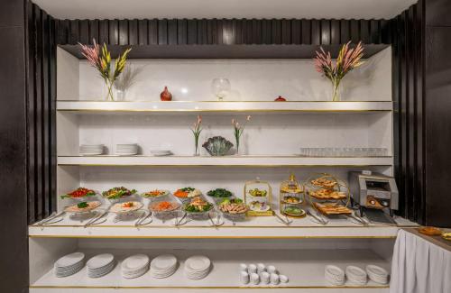 a refrigerator filled with lots of different types of food at ELC Luxury Hotel Danang - An Thuong Walking Street in Da Nang