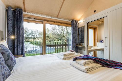 una camera da letto con un letto con una grande finestra di Lodge 16 a Wareham